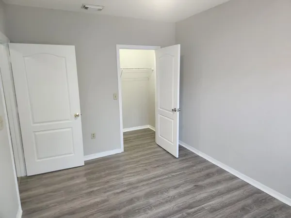 an empty room with wooden floor and closet