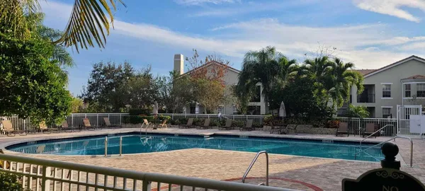 a view of a swimming pool with a patio and a yard