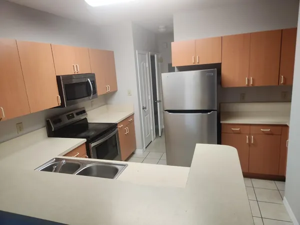 a kitchen with stainless steel appliances granite countertop a refrigerator and a stove top oven