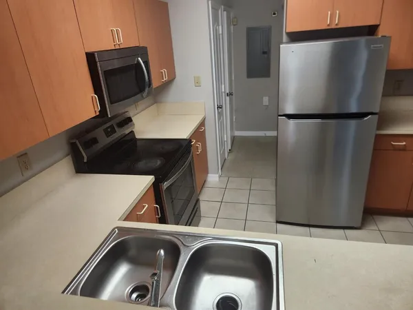 a kitchen with a refrigerator and a stove top oven