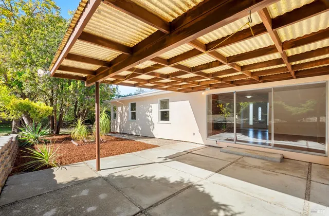 a view of a patio with a table and chairs under an umbrella