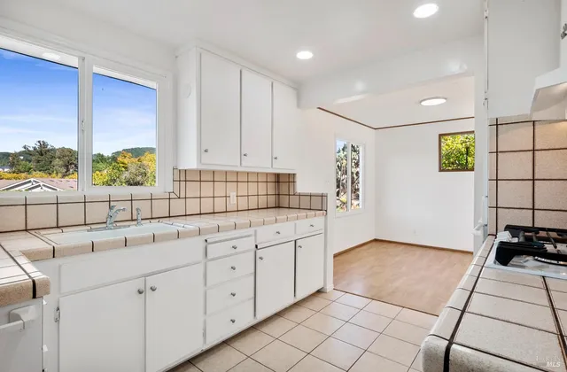 a kitchen with white cabinets and white appliances