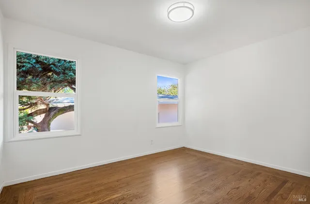 an empty room with window and wooden floor