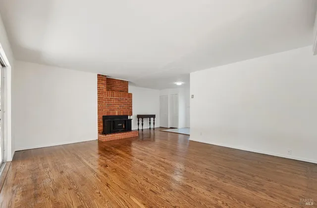 a view of a livingroom with wooden floor and fireplace