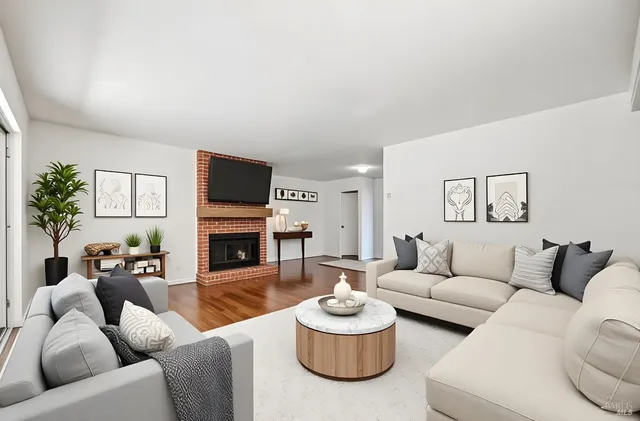 a living room with furniture a fireplace and a flat screen tv