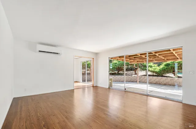 a view of empty room with wooden floor and floor to ceiling window