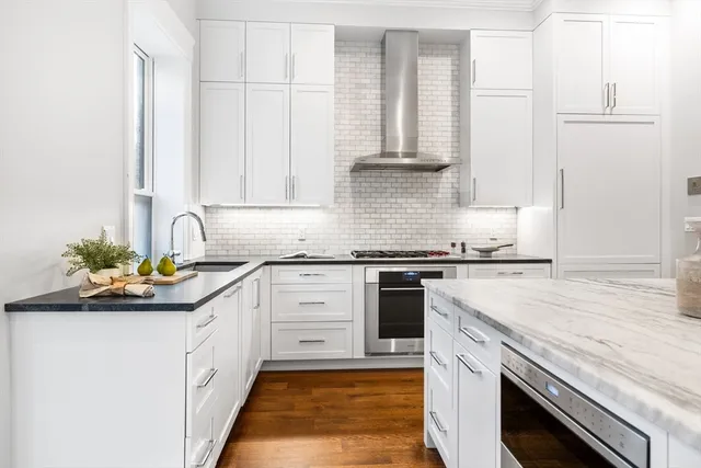 a kitchen with stainless steel appliances granite countertop a sink and dishwasher a stove top oven with wooden floor