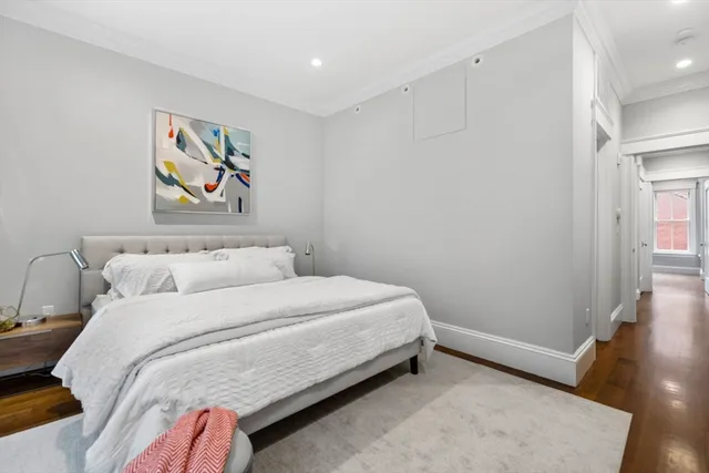 a bedroom with a bed and painting on the wall