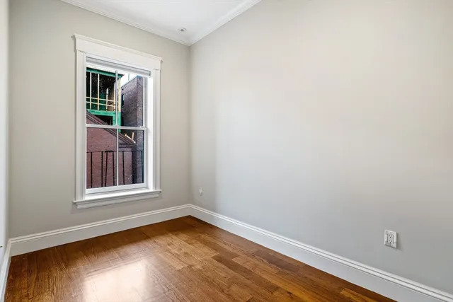 a view of a small space with wooden floor and a window