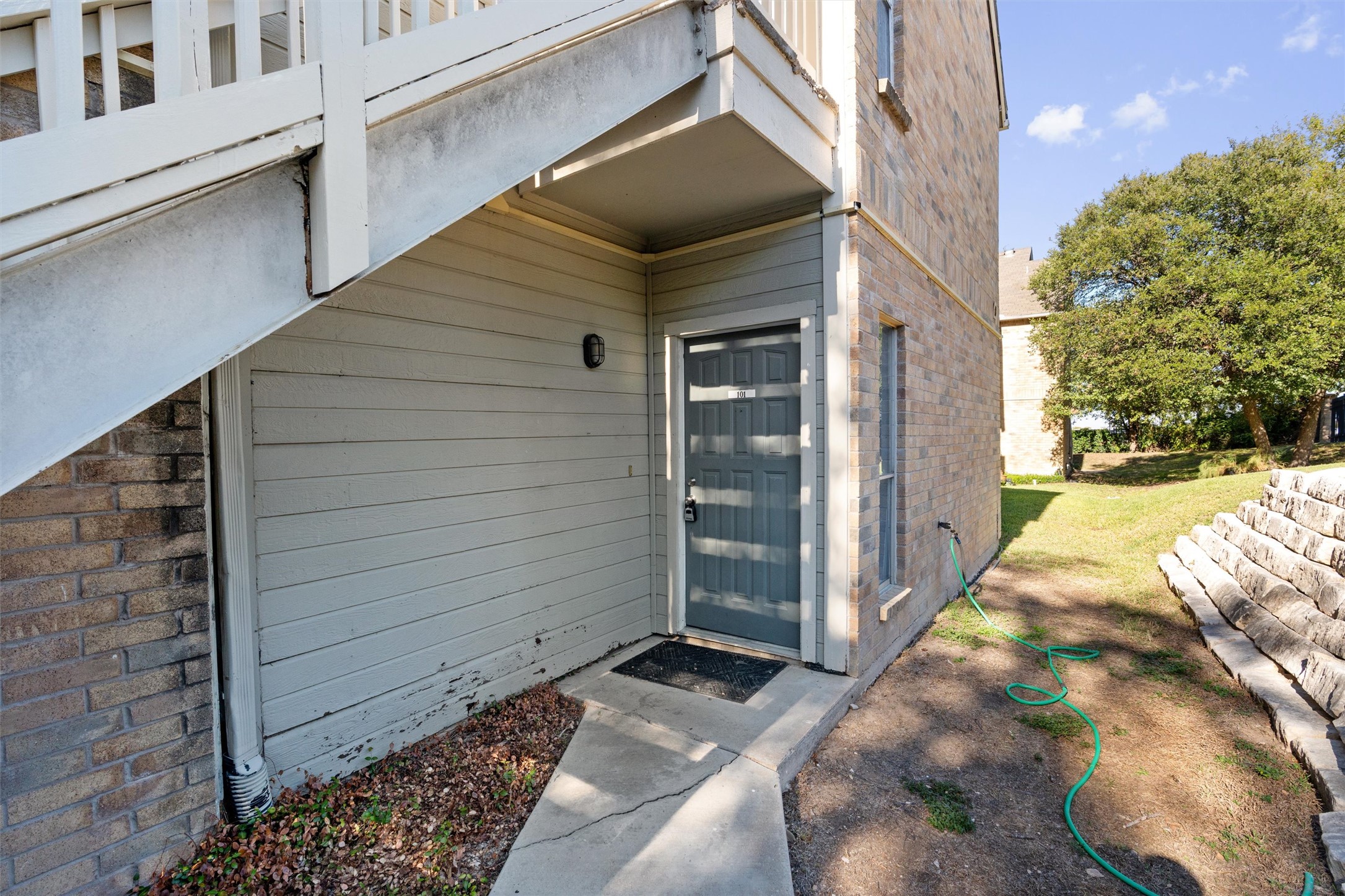 Entrance to property with brick siding and a yard
