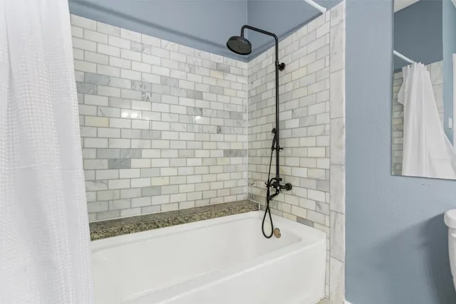 a bathroom with a bathtub and shower