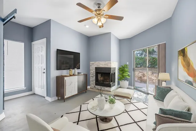 a living room with furniture a flat screen tv and a fireplace