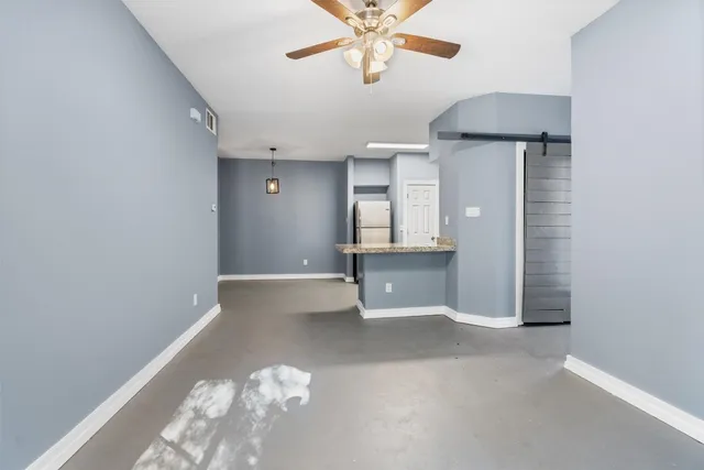 en empty room with window and ceiling fan