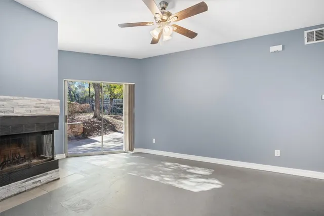a view of an empty room with a fireplace and a window