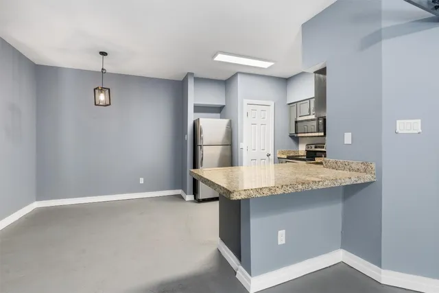 a kitchen with kitchen island a counter top space and stainless steel appliances