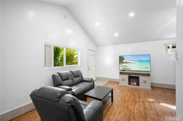 a living room with furniture a window and a flat screen tv