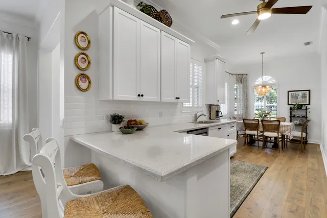 a living room with furniture a flat screen tv and kitchen view