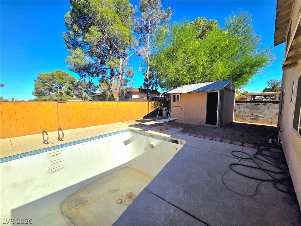 3648 Bronco Road Las Vegas, NV 89103 - Photo 17 of 24 A private backyard oasis features an in-ground pool, a shed, and concrete patio space for outdoor enjoyment.
