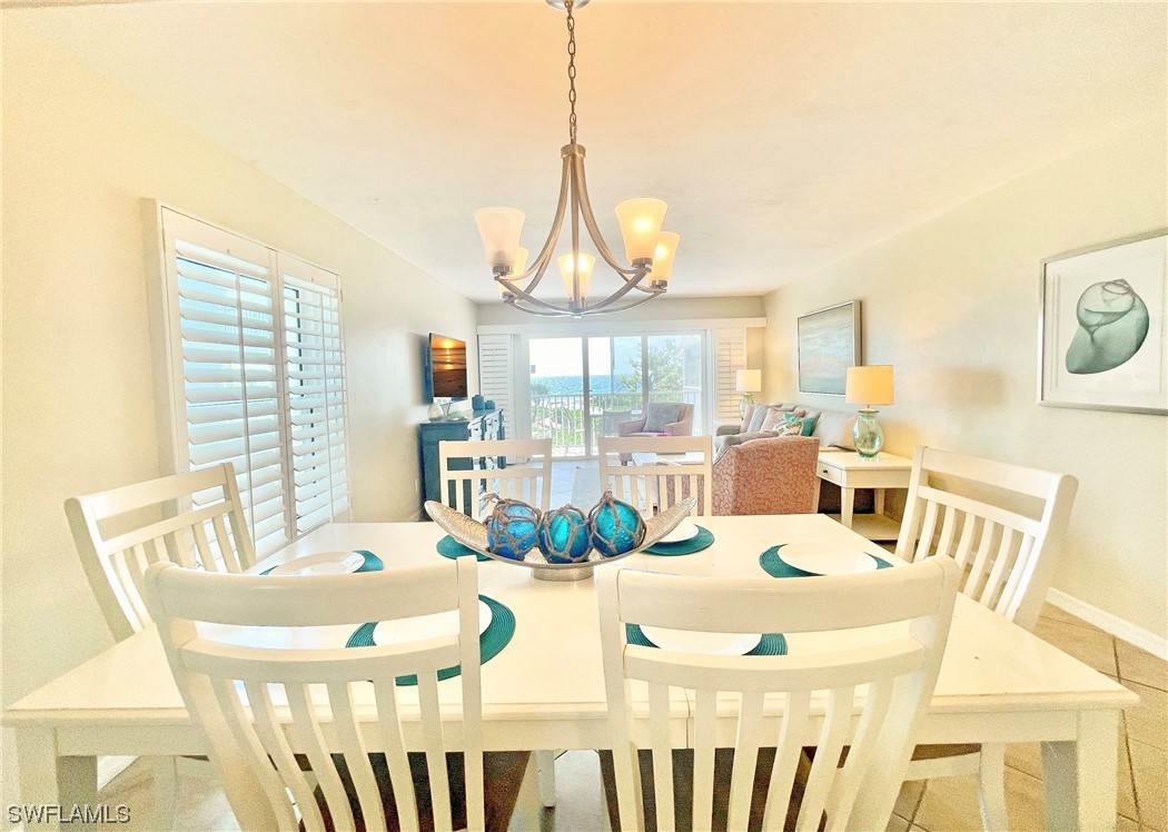 2521 Beach Villas Captiva, FL 33924 - Photo 11 of 50 a dining room with furniture a chandelier and wooden floor