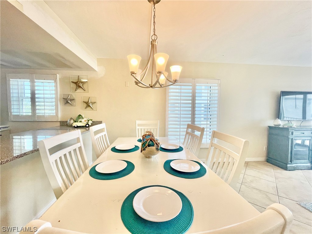 2521 Beach Villas Captiva, FL 33924 - Photo 12 of 50 a view of a dining room with furniture a chandelier and wooden floor