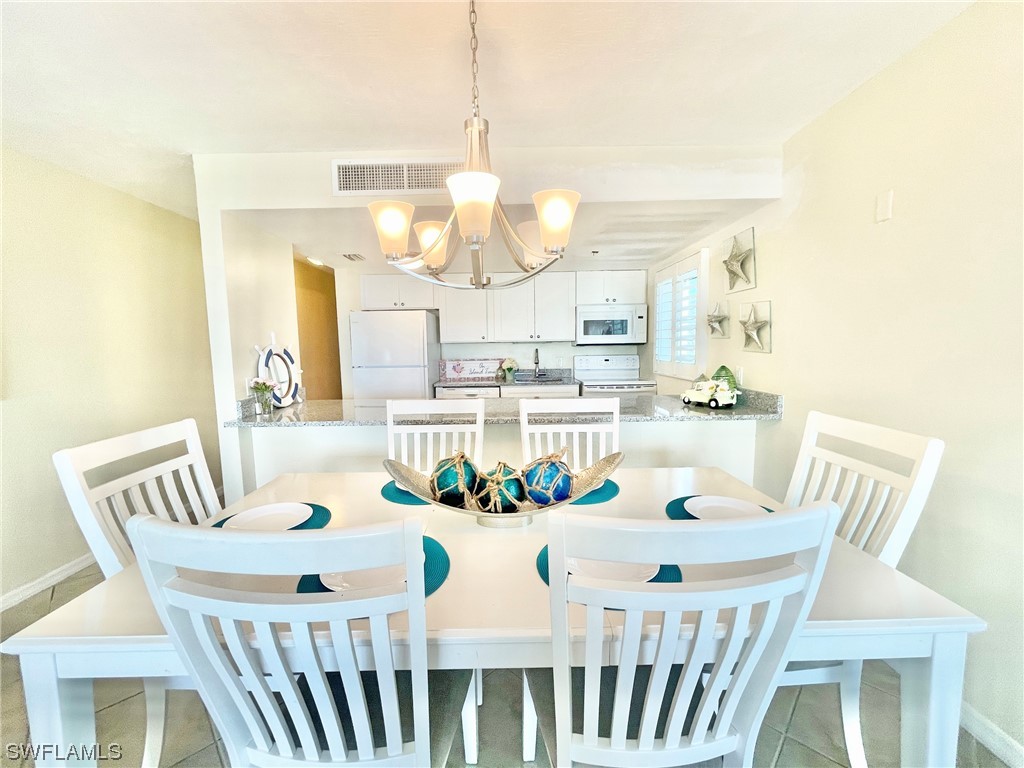 2521 Beach Villas Captiva, FL 33924 - Photo 14 of 50 a view of a dining room with furniture a chandelier and wooden floor