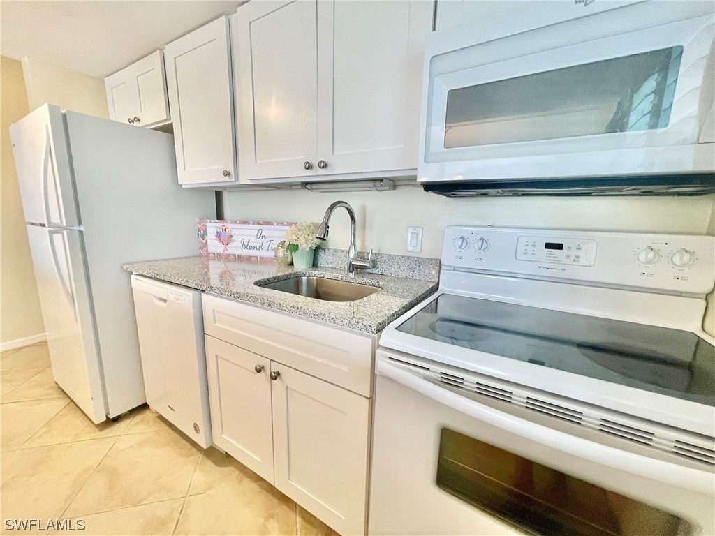 2521 Beach Villas Captiva, FL 33924 - Photo 17 of 50 a kitchen with white cabinets and refrigerator