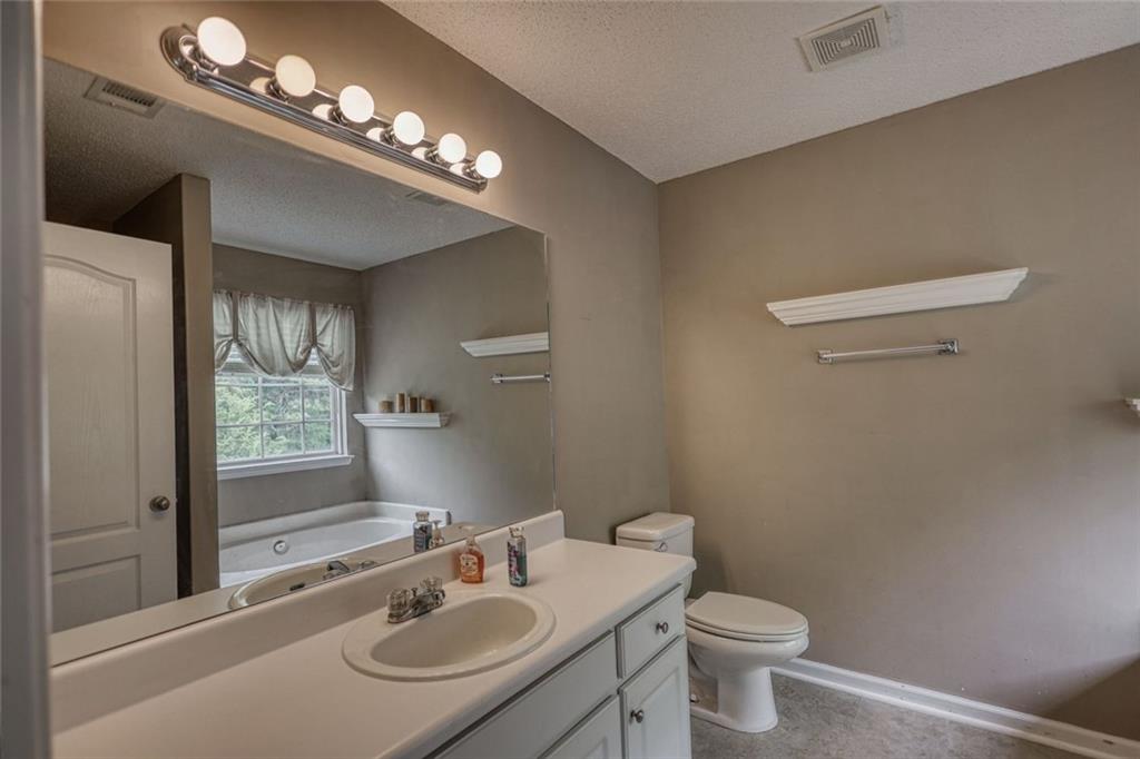 1916 Brenda Street Statham, GA 30666 - Photo 14 of 21 a bathroom with a sink a toilet and a mirror