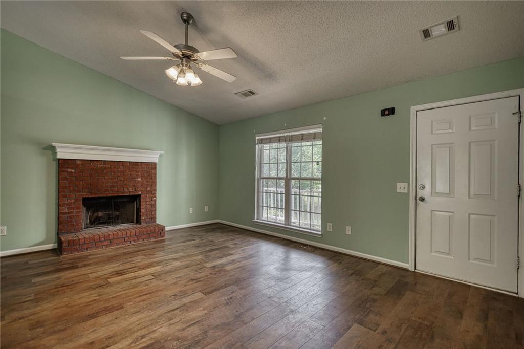 1916 Brenda Street Statham, GA 30666 - Photo 6 of 21 a view of an empty room with wooden floor fireplace and a window
