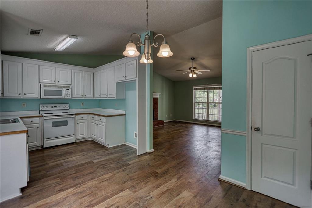 1916 Brenda Street Statham, GA 30666 - Photo 7 of 21 a kitchen with stainless steel appliances granite countertop a refrigerator a sink dishwasher a stove and white cabinets with wooden floor