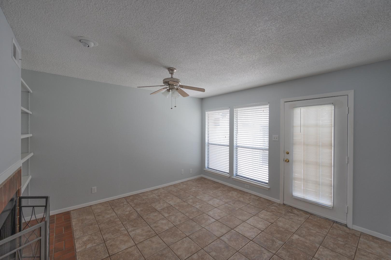 2110 Rio Grande Street, Unit 307 Austin, TX 78705 - Photo 4 of 12 A well-lit interior space features tile flooring and a refreshing ceiling fan.