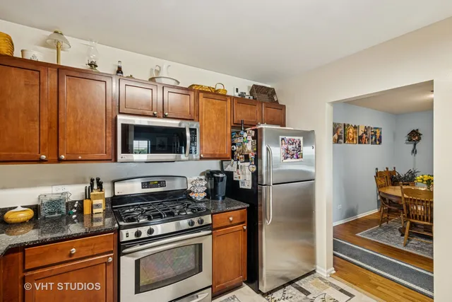 a kitchen with stainless steel appliances granite countertop a refrigerator stove and sink