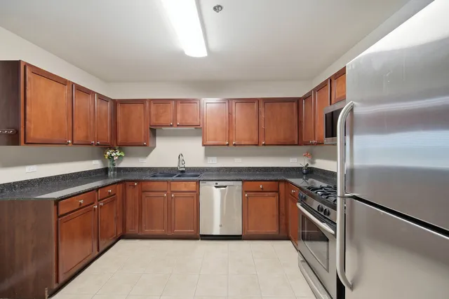 a kitchen with granite countertop a sink stainless steel appliances and cabinets
