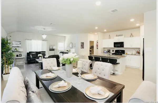 a kitchen with stainless steel appliances kitchen island granite countertop a dining table and chairs