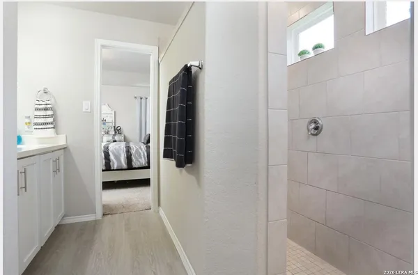 a walk in closet and view of bathroom
