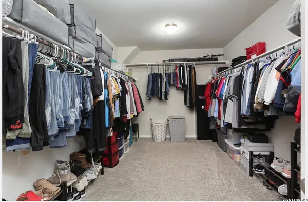 a view of walk in closet with clothes and shoes