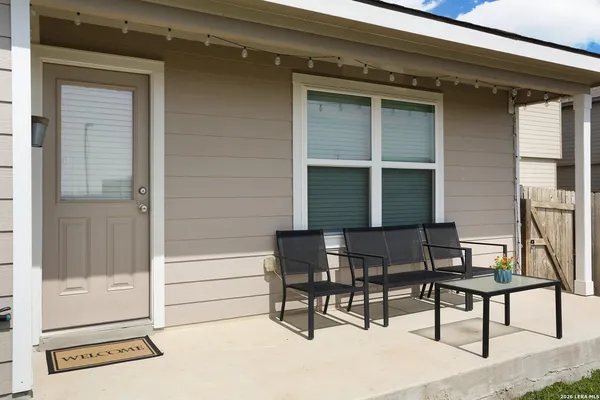 a view of a backyard with table and chairs and potted plants