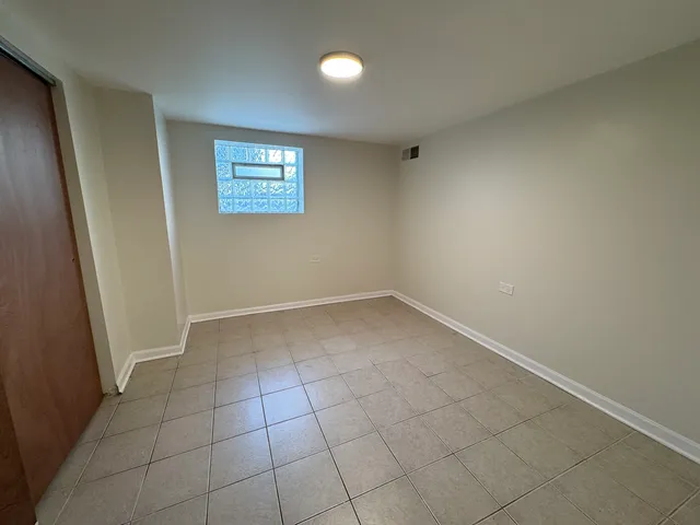 an empty room with a white walls and tiles