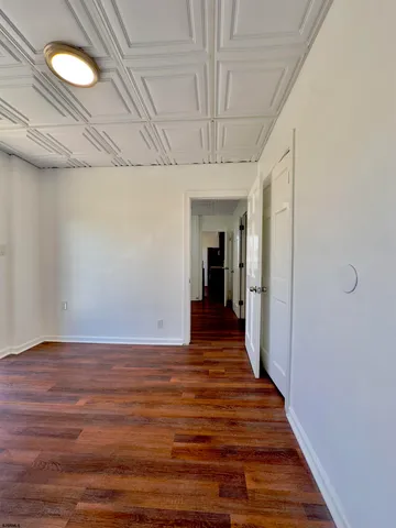 a view of a room with wooden floor and a window