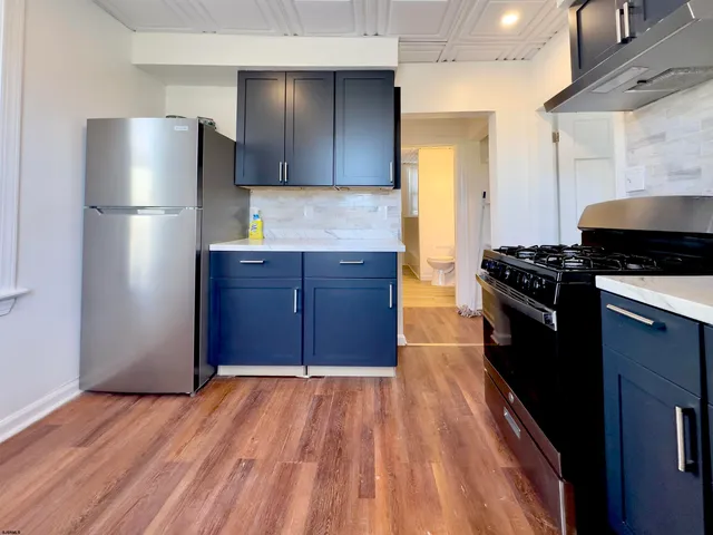 a kitchen with stainless steel appliances granite countertop a refrigerator and a stove