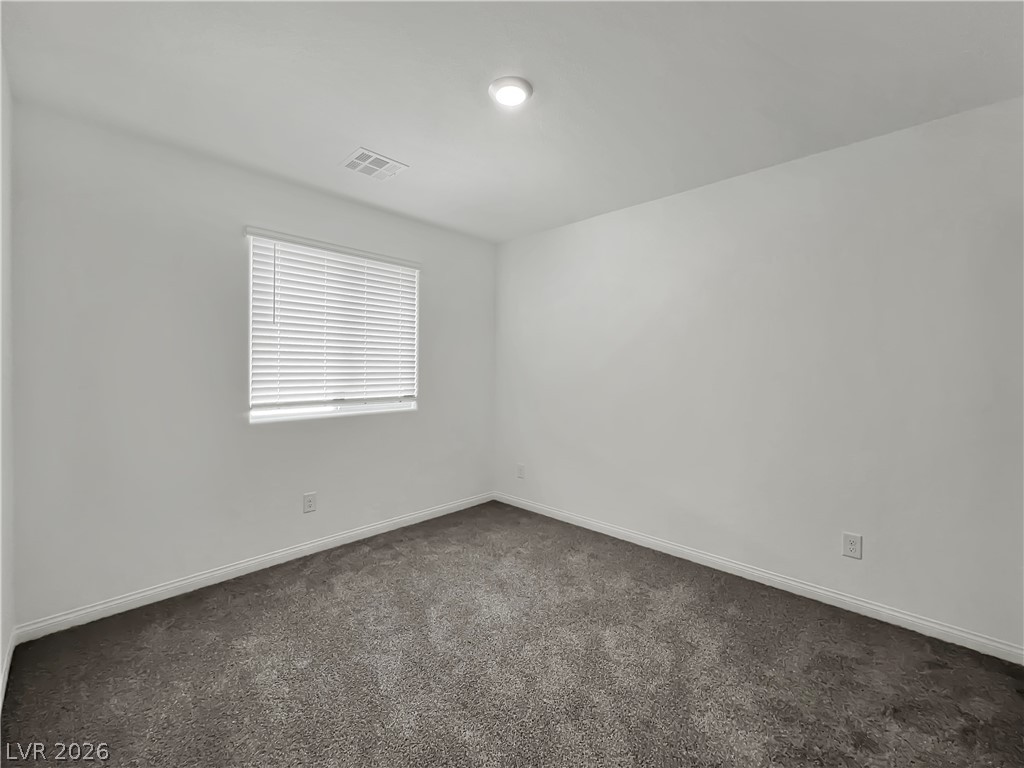 9984 Indigo Cliffs Street Las Vegas, NV 89141 - Photo 20 of 31 Unfurnished room featuring baseboards, visible vents, and dark carpet