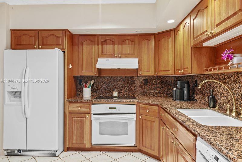 18455 Southwest 284th Street Homestead, FL 33030 - Photo 10 of 15 a kitchen with granite countertop a refrigerator and a stove top oven