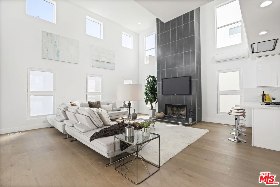 124 Roma Court Marina del Rey, CA 90292 - Photo 21 of 50 a living room with furniture a fireplace a dining table and a large window