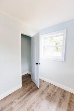 an empty room with wooden floor and a window