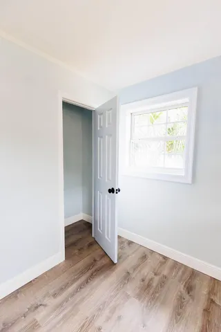 an empty room with wooden floor and a window