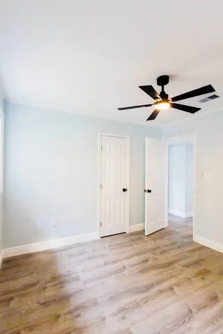 a view of room with wooden floor and ceiling fan