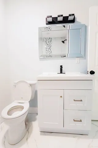 a bathroom with a toilet sink and mirror