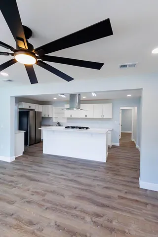 a view of kitchen with kitchen island a sink and wooden floor
