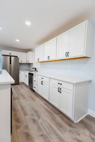 a kitchen with white cabinets and white appliances