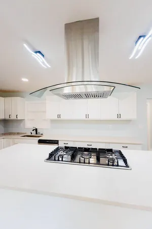 a kitchen with a stove and white cabinets