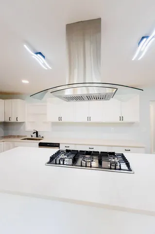 a kitchen with a stove and white cabinets